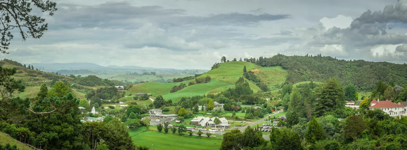 Green rolling hills and village in New Zealand's South Island