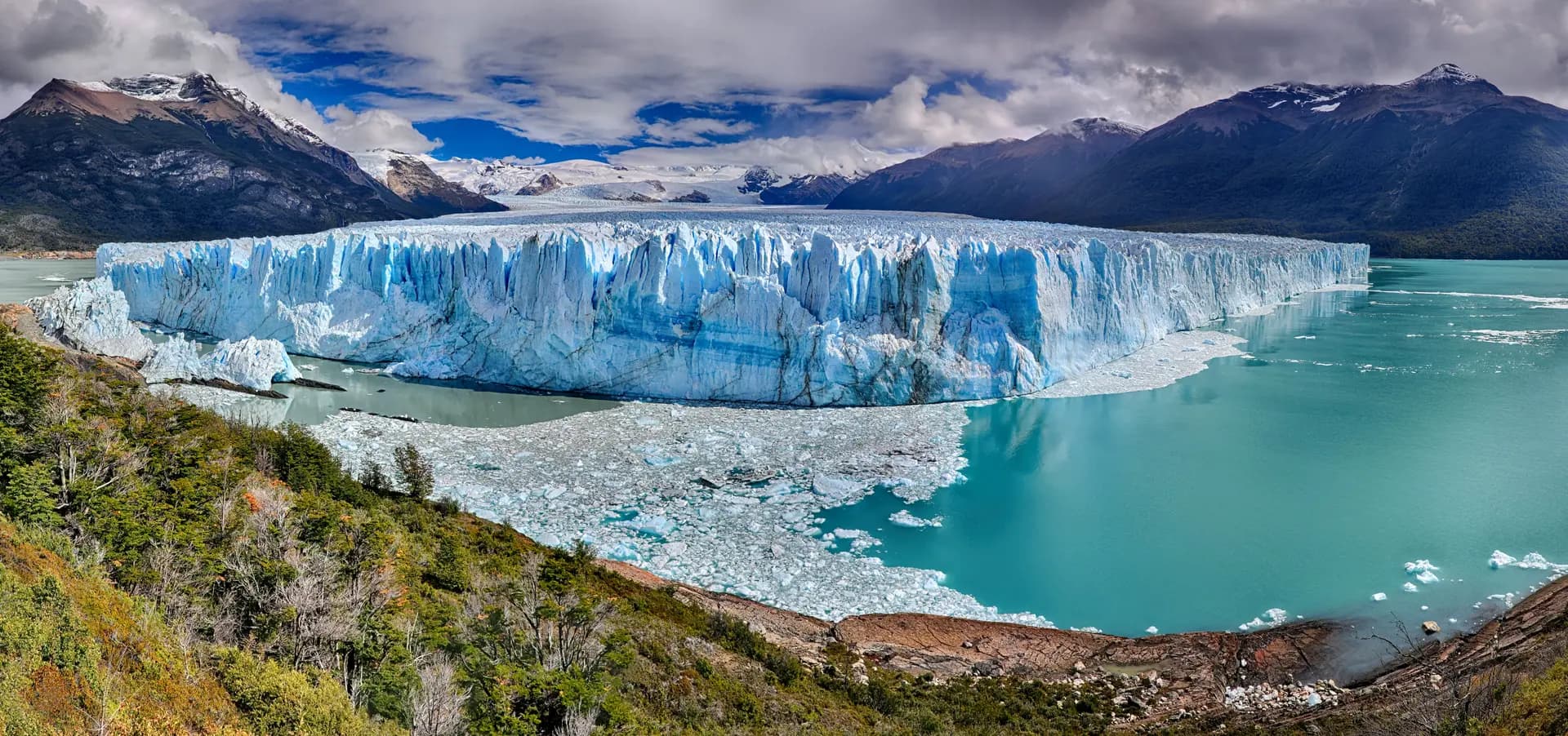 Perito Moreno Glacier calving into turquoise waters surrounded by Patagonian wilderness